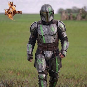 Puede incluir: Una armadura mandaloriana gris y verde met&aacute;lica detallada. La armadura presenta un casco, peto, hombreras y protectores de piernas, todos con detalles verdes. La imagen incluye el texto "Keepiron" en la esquina superior izquierda.