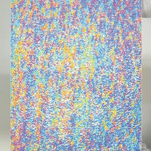 May include: A rectangular artwork with a pointillist design in various colours. The piece has a dense pattern of small dots in shades of blue, yellow, pink, and purple, creating a textured appearance. The artwork is held by gloved hands.