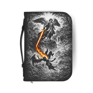 Puede incluir: Estuche negro con cremallera que presenta una detallada ilustración en blanco y negro de un ángel con una espada llameante luchando contra una figura caída. La obra de arte representa una escena dramática con un fondo de bosque y una cascada.
