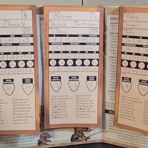May include: Three character sheets for a tabletop role-playing game, each with a wooden frame. The sheets feature character names, stats, and game mechanics. The characters are named Wonk, Malrum, and Poppy.