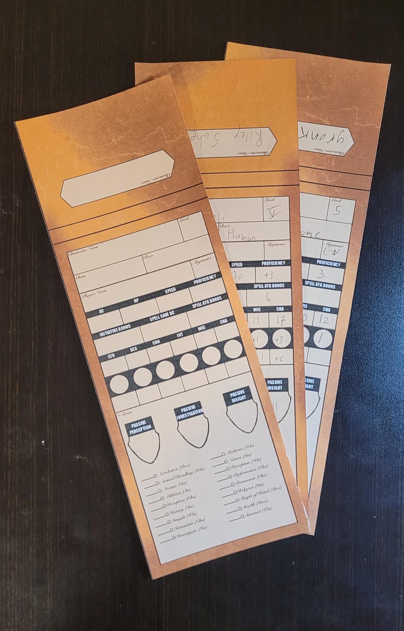May include: Three tan character sheets for a role-playing game, with brown borders. They feature sections for stats, skills, and abilities. Each sheet has a name at the top, with handwritten details. Measurements are not applicable.