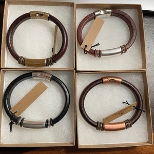 Pu&ograve; includere: Quattro braccialetti in pelle con dettagli in metallo. Ogni braccialetto &egrave; esposto in una scatola separata. I braccialetti sono di colore marrone, nero e marrone con dettagli in rame.