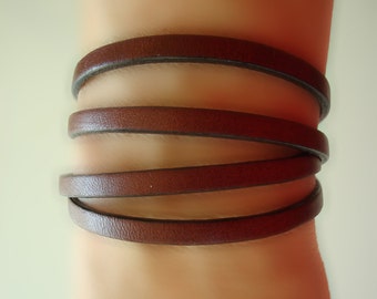 May include: A brown leather bracelet wrapped around a wrist four times.