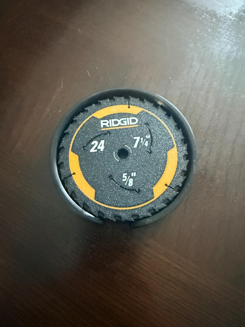 May include: A black and yellow Ridgid hole saw blade with a 7 1/4 inch diameter and a 5/8 inch arbor size. The blade has 24 teeth and is in a black container.