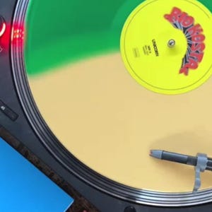 Op de afbeelding: Een vinylplaat op een platenspeler met een blauwe albumhoes. De plaat is groen en geel met een rood en geel label. De albumhoes is blauw met de tekst "RIO KOOS" in geel.