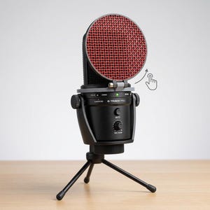 May include: A black G Track Pro microphone with a red mesh screen, mounted on a black tripod. The microphone has a mute button and a mic gain control. The screen is hinged and can be moved. The microphone is designed for recording.