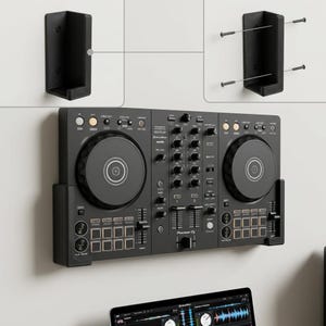 Puede incluir: Un soporte de pared negro para controlador DJ que incluye dos soportes en forma de L con orificios pretaladrados para tornillos. El soporte sostiene un controlador DJ Pioneer negro con dos ruedas jog circulares, perillas y deslizadores.