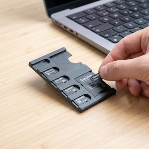 May include: A set of three ceramic mugs with a speckled, matte finish. Each mug features a different color: light blue, cream, and gray. The mugs have a simple, modern design and a comfortable handle.