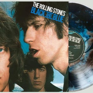 May include: Album cover for The Rolling Stones' "Black and Blue" featuring band members. The album art has a blue and black colour scheme. A vinyl record with a blue and black design is visible.