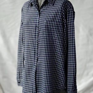 May include: A white ceramic mug with a black handle and the text "But First, Coffee" in a black, bold font. The mug is on a white surface.