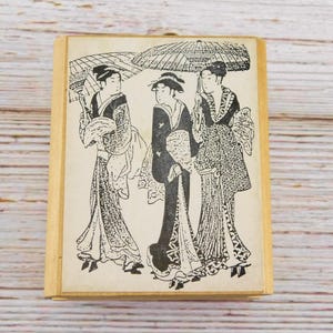 Sello de goma "Trío de geishas japonesas": Mujeres asiáticas con kimono y sombrilla, montado en madera, para crear tarjetas y proyectos artísticos.