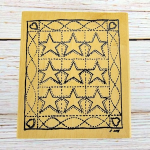 May include: A rectangular wooden stamp featuring a grid of six stars in a dotted outline design. The stamp has a decorative border with hearts and dotted lines. The stamp is light brown with black ink.