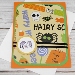 May include: Halloween greeting card with an orange border and a light yellow background. The card features a variety of Halloween-themed illustrations, including spiders, a skull, and candy corn. The text "Happy Halloween" and "Hairy Scary" are visible.