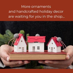 Informational slide, "More handcrafted ornaments and holiday decor await you in the shop..." with image of three gray thatched-roof ornaments on a red book.