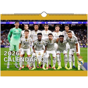 Puede incluir: Un calendario del Real Madrid de 2026 con una foto del equipo de jugadores de fútbol con uniformes blancos. El calendario tiene una encuadernación en espiral en la parte superior y las palabras "2026 CALENDARIO REAL MADRID" están impresas en la parte inferior izquierda.