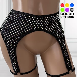 May include: A black high-waisted garter belt featuring an all-over pattern of iridescent rhinestones. The garment includes two leg straps connected by metal rings at the bottom. A graphic in the corner displays color circles and the text +99 COLOR OPTIONS.