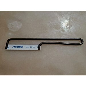 May include: A black coping saw with a flexible blade. The blade has the word "Flexible" printed on it, along with "Largo 305 mm 12". The saw is designed for cutting curves and intricate shapes in wood and other materials.