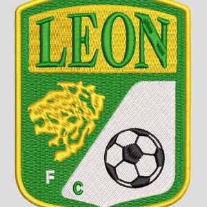 Pode incluir: Um emblema bordado em forma de escudo com a palavra LEON em letras verdes sobre um fundo amarelo. O emblema inclui uma cabeça de leão amarela, uma secção triangular branca com uma bola de futebol preta e branca, as letras F e C, e sete estrelas amarelas.