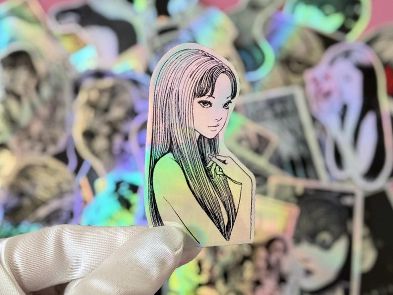 May include: Holographic sticker featuring a manga-style illustration of a woman with long, straight hair and a delicate expression. The sticker has a pearlescent, iridescent finish, with a soft color gradient. The background shows other stickers.