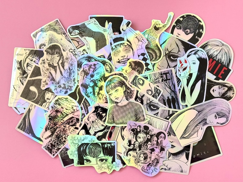 May include: A collection of holographic stickers featuring manga-style illustrations. The stickers depict various characters and scenes in black and white, with some accents of color. The stickers are arranged on a pink surface.
