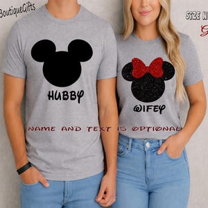 May include: Matching gray t-shirts with black Mickey Mouse head silhouettes. One shirt says "Hubby" and the other says "Wifey" with a red glitter bow. The text "Name and Text is Optional" is also visible.