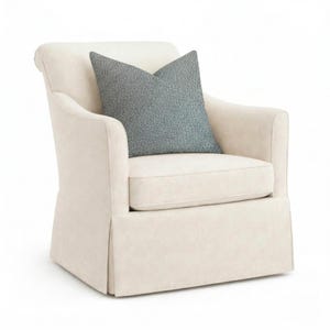 May include: A white ceramic mug with a black handle and the text "But First, Coffee" in a bold, black font. The mug is set against a blurred background, suggesting a cozy setting.