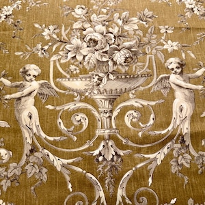 May include: A decorative fabric with a repeating pattern of cherubs, floral arrangements, and ornate scrollwork in shades of gold and cream. The design features detailed illustrations of angels with wings, holding floral garlands, and large urns filled with flowers.