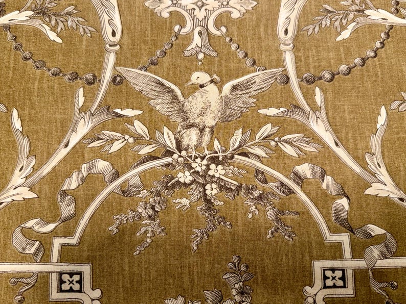 May include: A detailed pattern featuring a central bird with outstretched wings, surrounded by floral and ribbon motifs. The design is in shades of cream and brown, creating a vintage aesthetic. The background has a textured appearance.