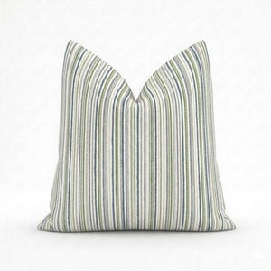 May include: A cushion featuring a vertical striped design in white, blue, and green. The fabric has a textured finish. This decorative cushion is suitable for home interiors. The stripes are evenly spaced, offering a contemporary aesthetic.