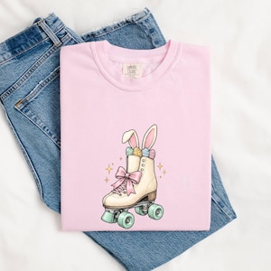 Maglietta con coniglietto sui pattini a rotelle, regalo di Pasqua per pattinatori, maglietta carina da donna con coniglietto, maglietta primaverile con coniglietto di Pasqua, grafica da pattinaggio disegnata a mano e decorata