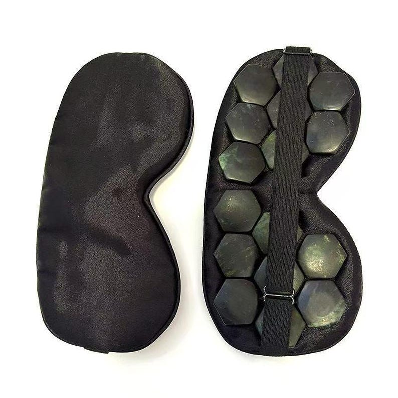 May include: Two black eye masks. One is a solid, smooth, satin-like material. The other has a series of dark, hexagonal stones attached, with a black elastic strap. The masks are designed to cover the eyes.