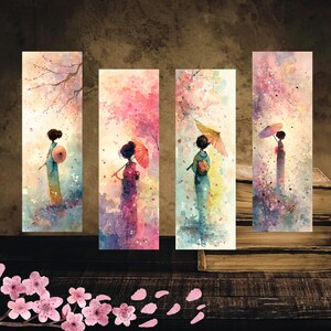 以下が含まれることがあります： 桜の木の下で着物を着た芸者を特徴とする4つの水彩画のブックマーク。各ブックマークは、ピンク、紫、青など、さまざまな色で異なるシーンを描いています。ブックマークは、本のある暗い木製の表面に置かれています。