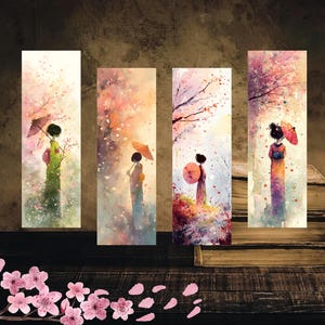 以下が含まれることがあります： 桜の木の下で傘をさす芸者を水彩画で描いた4つのブックマーク。各ブックマークは、ピンク、オレンジ、紫の色合いで、異なる配色になっています。ブックマークは、本と一緒に木製の表面に表示されています。