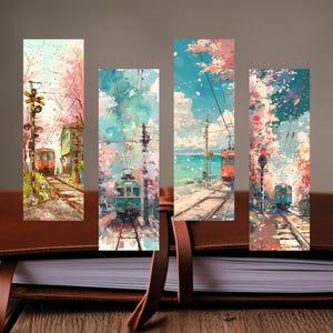以下が含まれることがあります： 桜の風景と電車を描いた水彩画のブックマーク4点セット。各ブックマークは異なる電車と風景を描き、柔らかいピンク、青、緑の色合いを使用。ブックマークは茶色の革のジャーナルに置かれています。