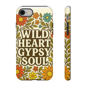 Op de afbeelding: Een telefoonhoesje met een bloemenontwerp en de woorden "WILD HEART GYPSY SOUL" in een retro lettertype. De hoes heeft oranje, gele en blauwe bloemen met groene bladeren tegen een crèmekleurige achtergrond. De zijkant van de hoes heeft ook een bloemenpatroon.