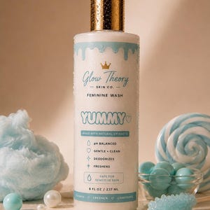 May include: A cylindrical bottle of Glow Theory Skin Co. feminine wash with a gold cap. The label features light blue text, a crown icon, and the word YUMMY. It lists features including pH balanced, gentle, clean, deodorizes, freshens, and safe for sensitive skin, with a volume of 8 fl oz / 237 ml.