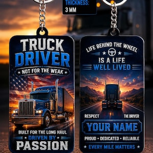 Peut inclure: Un porte-clés rectangulaire de 5 cm sur 3 mm d'épaisseur. Le recto présente un semi-remorque bleu, un drapeau américain et le texte : TRUCK DRIVER NOT FOR THE WEAK BUILT FOR THE LONG HAUL DRIVEN BY PASSION. Le verso montre un camion sur une route avec le texte : LIFE BEHIND THE WHEEL IS A LIFE WELL LIVED RESPECT THE DRIVER YOUR NAME PROUD DEDICATED RELIABLE EVERY MILE MATTERS.
