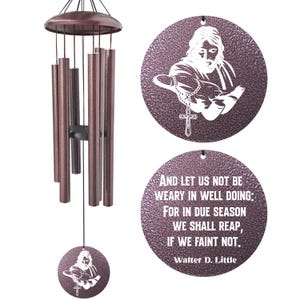 May include: Bronze-colored wind chimes with a circular pendant featuring a white image of Jesus holding a rosary and cross. The bottom pendant has an inspirational quote by Walter D. Little. The chimes have multiple bronze tubes.