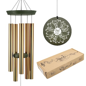 May include: A wind chime with gold-colored tubes and a dark green top and clapper. A round, dark green disc with the words "God say you are" and other positive affirmations is also shown. A cardboard box is in the image.