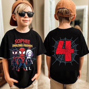 Puede incluir: Camiseta negra con el texto "SOPHIE AND HER AMAZING FRIENDS" y personajes de dibujos animados de Spider-Man. La parte trasera de la camiseta muestra un n&uacute;mero 4 rojo dentro de un dise&ntilde;o de telara&ntilde;a. La camiseta la lleva un ni&ntilde;o.