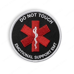 May include: Round black patch with white border and text "DO NOT TOUCH EMOTIONAL SUPPORT EMT". Features a red Star of Life symbol with a white caduceus in the center. The patch is likely for medical or emergency services.