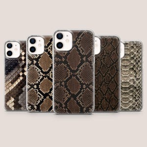 Può includere: Cinque custodie rettangolari per smartphone disposte in fila, ognuna caratterizzata da un distinto motivo a pelle di serpente. I design mostrano varie texture e palette di colori, tra cui tonalità marroni, nere, beige e grigie.