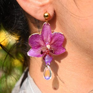 Earrings made with 100% real orchids preserved in resin, gold-plated stainless steel, and a Murano glass pendant. Exclusive