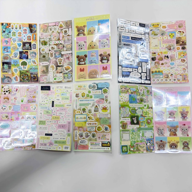 May include: A collection of ten rectangular sticker sheets featuring various cartoon characters, including Rilakkuma bears, small animals, and food items. The sheets display diverse designs with colorful illustrations, Japanese text, and decorative borders.
