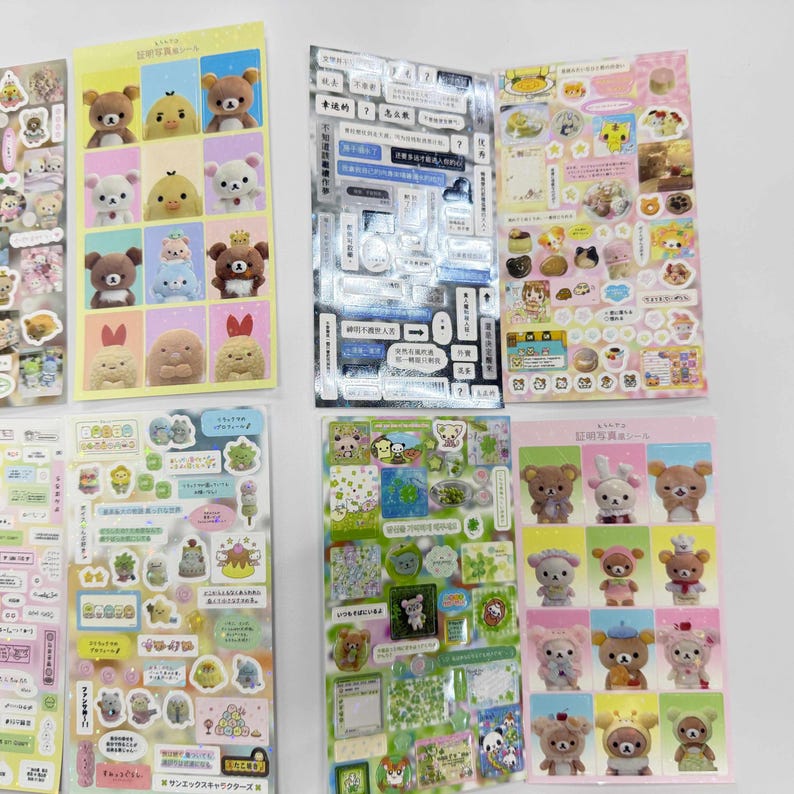 May include: A collection of six rectangular sticker sheets featuring various San-X character designs, including Rilakkuma bears, Korilakkuma, and Kiiroitori. The sheets display grid layouts of plush figures, small decorative icons, text labels, and patterned motifs in diverse colors.
