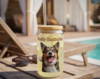 May include: A clear glass tumbler with a bamboo lid and a glass straw. The tumbler features a smiling dog graphic with the text "Easily Excitable!". The glass is filled with a yellow liquid and lemon slices. Sunglasses rest on a wooden surface.