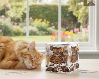 May include: An orange tabby cat sleeps next to a white cube adorned with cat illustrations. The cube features the text "Get it done". A window with a garden view is visible in the background.