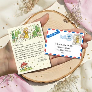 May include: A charming tooth fairy note and envelope. The note has a fairy illustration, trees, and a message thanking Amelia for her tooth. The envelope is addressed to Amelia Smith with a fairy post stamp and "FAIRY MAIL" banner.