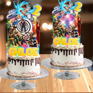 May include: Two white cakes with chocolate ganache drips and colorful sprinkles on glass stands, each topped with a Street Fighter themed cake topper featuring characters, a large yellow number two, and the name CHLOE in yellow lettering.