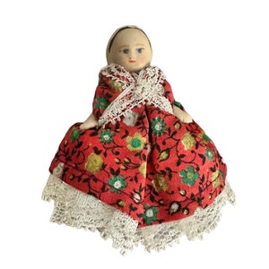 Antique dollhouse doll in red dress